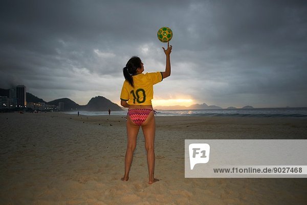Reife Frau balanciert Fußball am Finger  Copacabana Strand  Rio De Janeiro  Brasilien