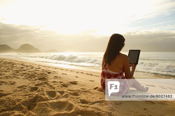 Reife Frau mit digitalem Tablett am Strand von Copacabana  Rio De Janeiro  Brasilien