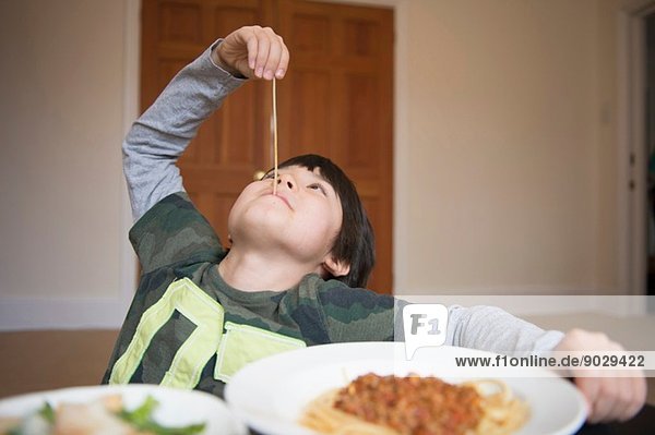 Boy playing with spaghetti