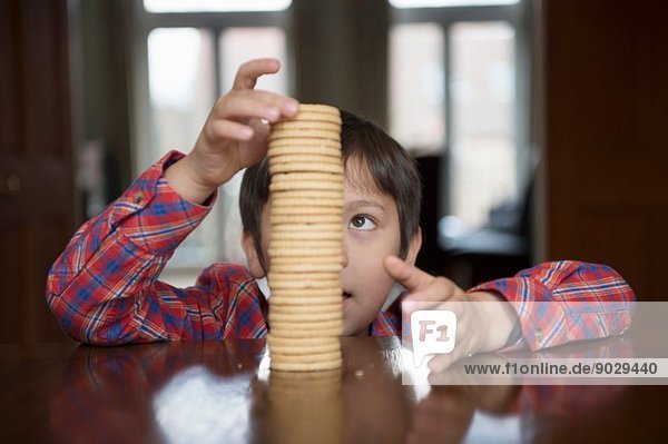 Boy stacking up biscuits