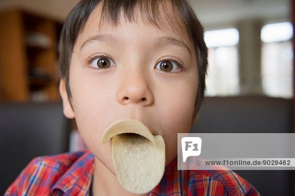Junge imitiert Vogelschnabel mit Chips