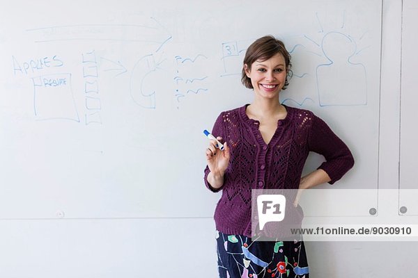 Portrait of young woman in front of whiteboard