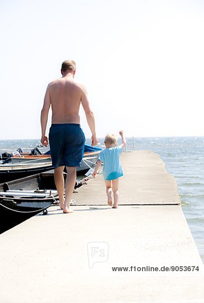 Father with son walking on jetty  Gotland  Sweden