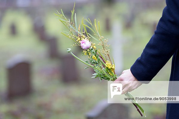 Hand with flowers on graveyard  Skogskyrkogarden  Stockholm  Sweden