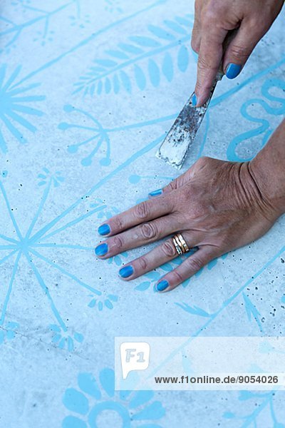 Woman peeling wallpaper  close-up