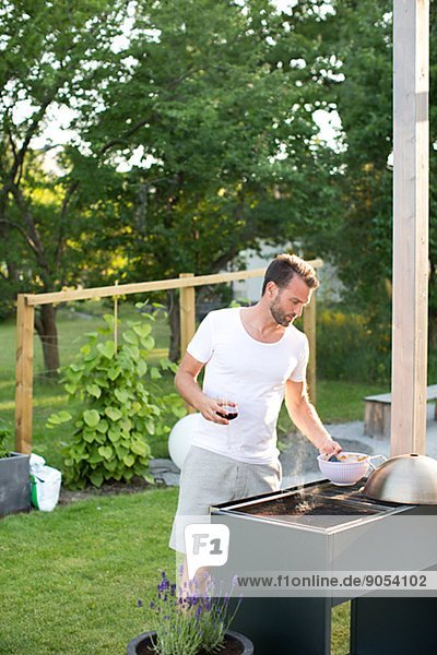 Man having grill in garden,  Stockholm,  Sweden