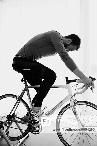 Mid adult man indoor cycling  studio shot