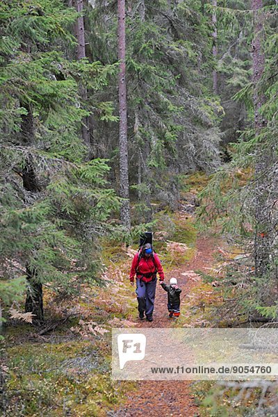 Mother with child walking through forest  Tiveden  Sweden