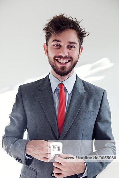 Portrait of smiling young man wearing suit  London  United Kingdom