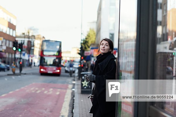 Young woman standing on bus stop