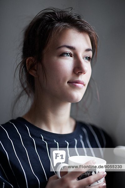 Portrait of young woman with mug  studio shot