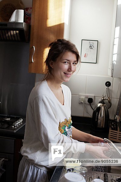 Smiling young woman in kitchen