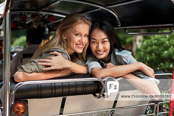 Smiling friends in rickshaw  Thailand