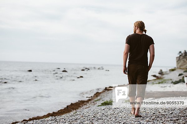 Young man walking on beach  Gotland  Sweden