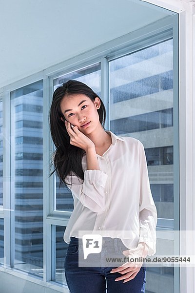 Young woman on corridor talking via ell phone  Thailand