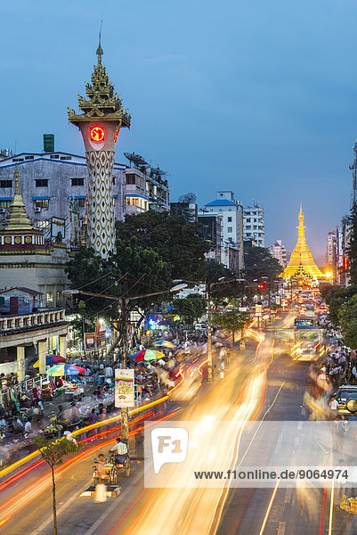 Clock tower  Sule Pagoda at the back  at dusk  blue hour  road traffic  Yangon or Rangoon  Yangon Region  Myanmar