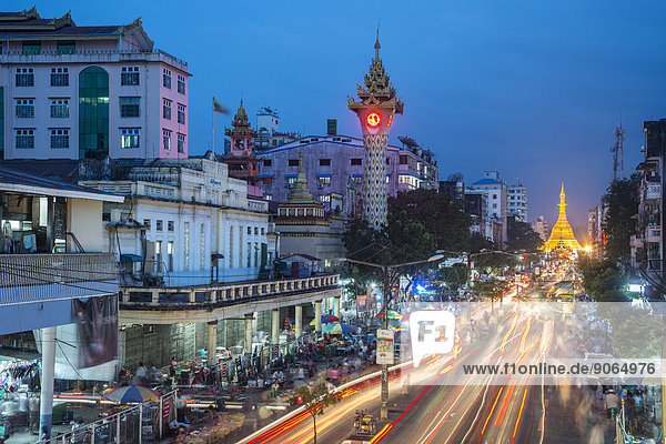 Clock tower  Sule Pagoda at the back  at dusk  blue hour  road traffic  Yangon or Rangoon  Yangon Region  Myanmar
