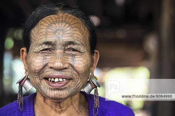 Frau mit traditioneller Gesichtstätowierung und Ohrenschmuck  Volksgruppe der Chin  ethnische Minderheit  Porträt  Rakhaing Staat  Myanmar