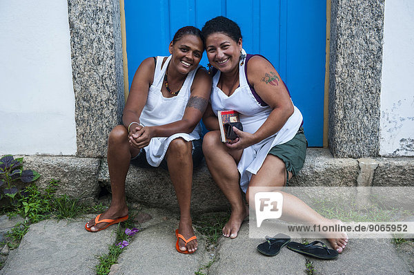 Two friendly women sitting on the doorstep  Paraty  Rio de Janeiro State  Brazil