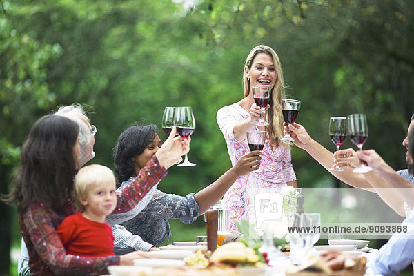 Woman toasting with red wine on a garden party
