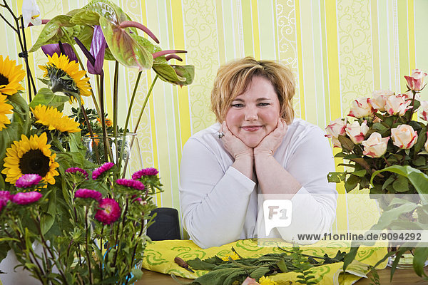 Mittlere erwachsene Frau im Blumenladen