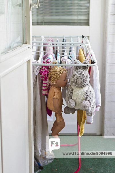 Kleidung  Puppe und Plüschtiere trocknen auf dem Wäscheständer am Balkon