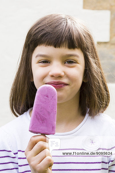 Porträt eines kleinen Mädchens mit Joghurt Blaubeereis Lolly