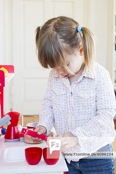 Kleines Mädchen spielt mit Kinderküche