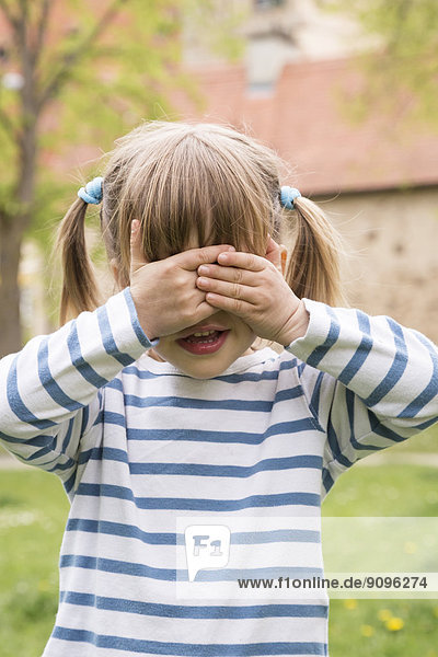 Little girl covering her eyes with hands