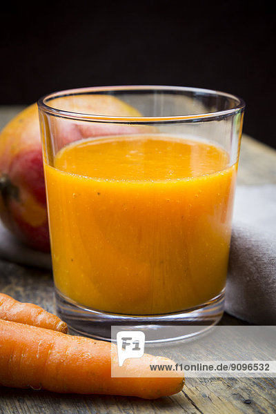 Glass of mango carrot smoothie  carrots and mango