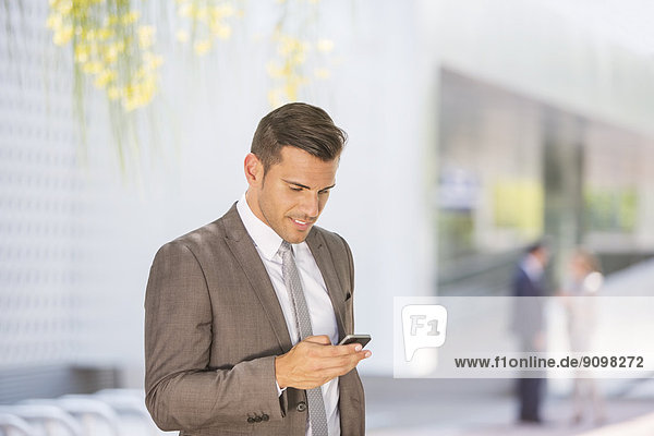 Geschäftsmann texting mit Handy im Freien
