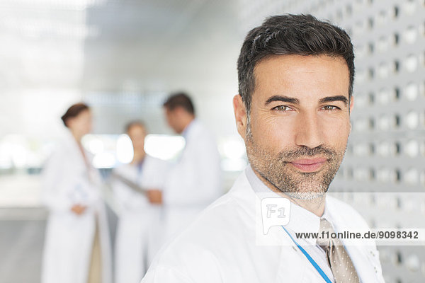 Portrait of confident doctor in hospital corridor