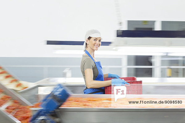 Porträt eines selbstbewussten Arbeiters mit Kiste in einem Lebensmittelbetrieb