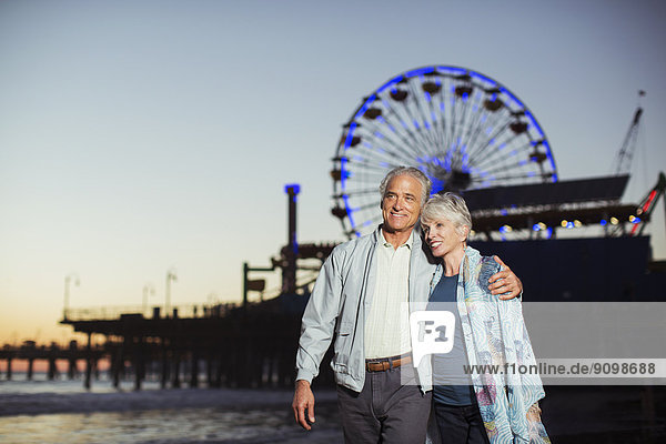 Seniorenpaar beim nächtlichen Strandspaziergang