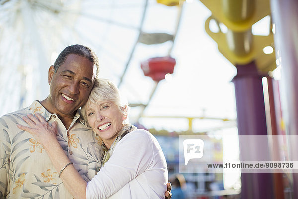 Porträt eines lächelnden Seniorenpaares im Vergnügungspark