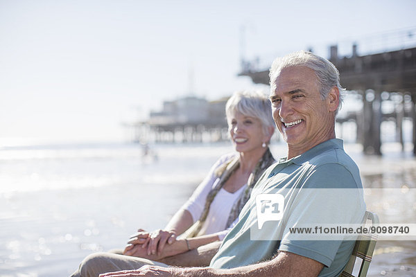 Porträt eines Seniorenpaares am sonnigen Strand