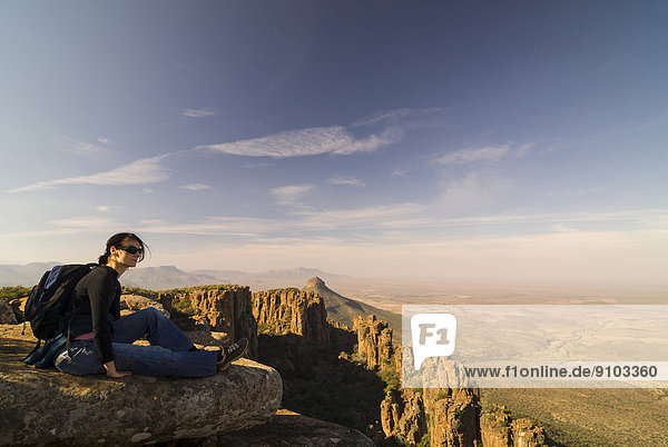 Wanderin genießt Ausblick auf die Spandau-Koppe und Camdeboo-Ebene  Felsenformationen und Steinsäulen im Tal Valley of Desolation  bei Graaff Reinet  Provinz Ostkap  Südafrika