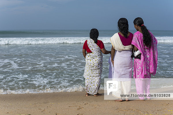 Women standing on the beach facing the sea  Varkala  Kerala  India
