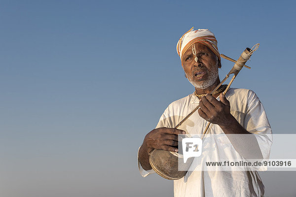 Musiker spielt auf einer Ektara  traditionelles Saiteninstrument mit einer Saite  Vrindavan  Uttar Pradesh  Indien