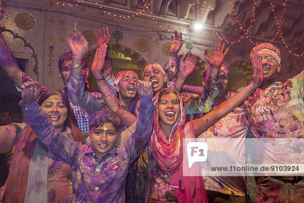 Devotees covered in coloured powder celebrating  Holi festival  Banke Bihari Temple  Vrindavan  Uttar Pradesh  India