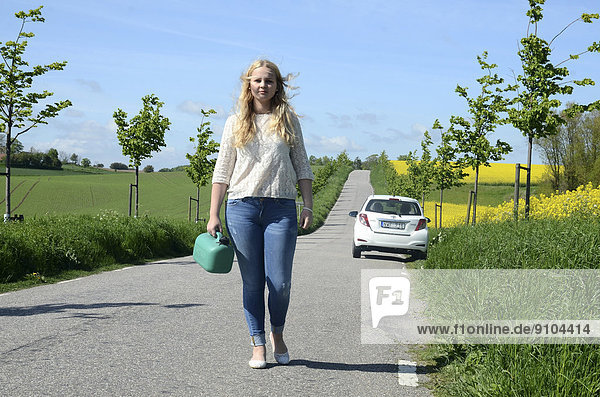 Frau mit einem Benzinkanister in der Hand entfernt sich von ihrem Auto  Schonen  Schweden