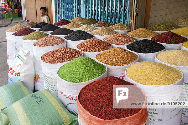 Marktverkäufer mit verschiedenen Sorten von Bohnen  Gewürzen und Getreiden  Saigon  Ho-Chi-Minh-Stadt  Vietnam