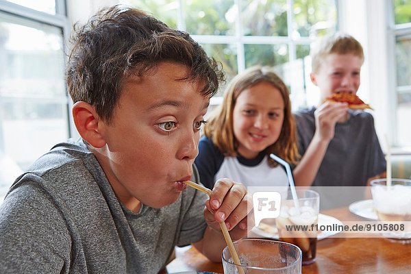 Boy drinking soft drink through straw