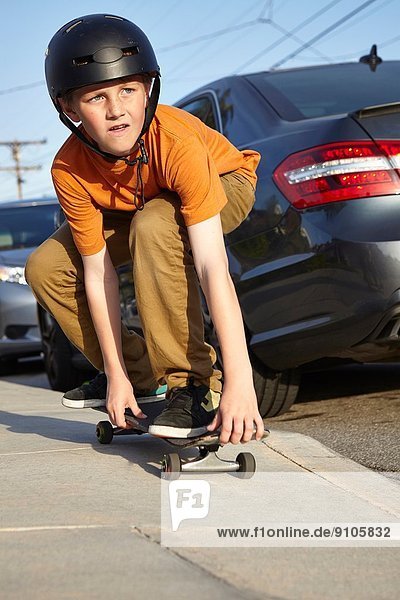 Boy skateboarding on pavement