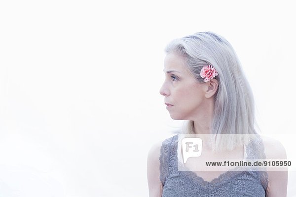 Porträt einer reifen Frau mit Blume im Haar