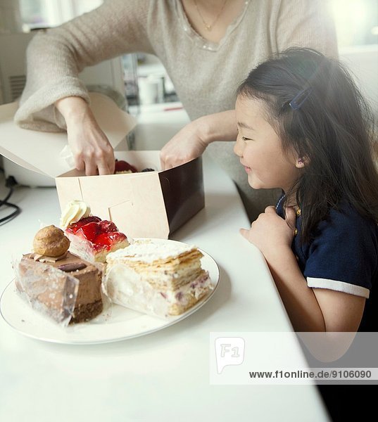 Mother and daughter with box of cakes