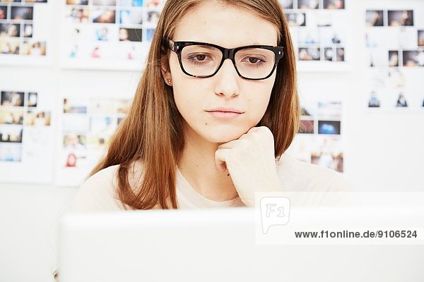 Junge Frau mit Brille am Computer