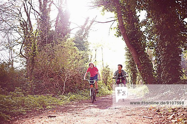 Boys cycling on forest path