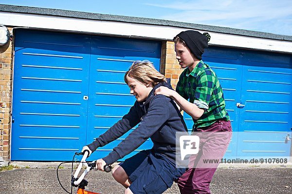 Junge  der einen Freund auf dem Fahrrad mitnimmt