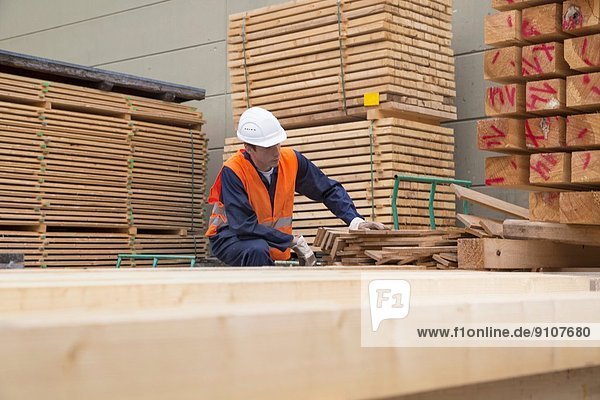 Holzarbeiter beim Sortieren von Holzbrettern im Holzplatz